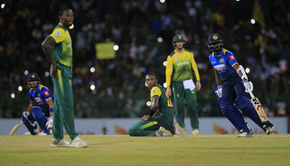 South Africa's Lungi Ngidi, third right, watches Sri Lanka's Dinesh Chandimal, left, and Isuru Udana complete the winning run, defeating South Africa by three wickets in their Twenty20 cricket match in Colombo, Sri Lanka, Tuesday, Aug. 14, 2018. (AP Photo/Eranga Jayawardena)