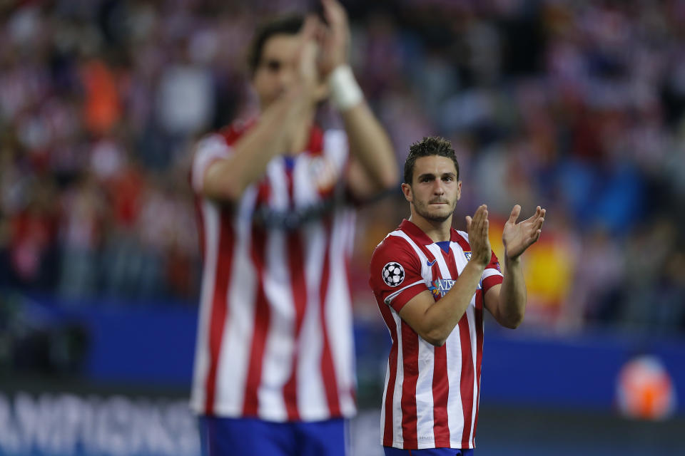 Atletico's Koke, right, and Tiago wave to Atletico supporters at the end of the Champions League quarterfinal second leg soccer match between Atletico Madrid and FC Barcelona at the Vicente Calderon stadium in Madrid, Spain, Wednesday, April 9, 2014. (AP Photo/Andres Kudacki)