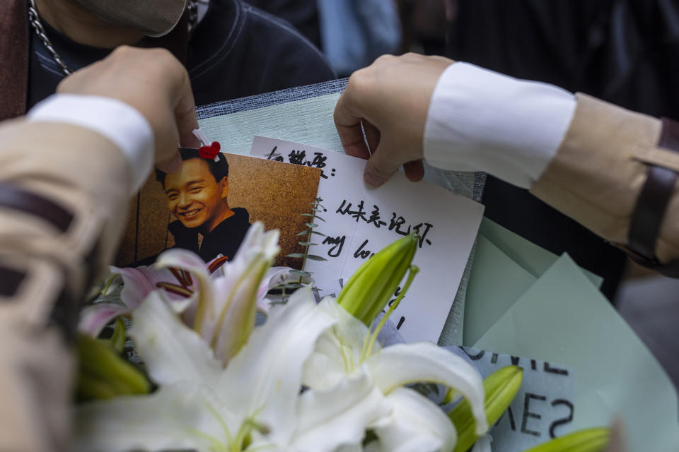 One of fans arranges a bouquet outside the Mandarin Oriental Hotel to commemorate the 20th anniversary of the passing of Canto-pop singer and actor Leslie Cheung in Hong Kong, Saturday, April 1, 2023. (AP Photo/Louise Delmotte)