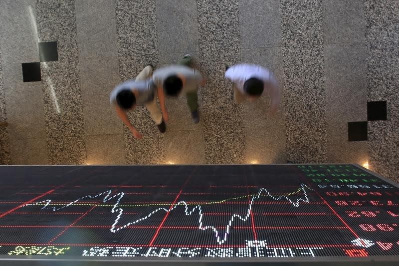 People walk under an electronic board showing stock information at the Shanghai Stock Exchange in Lujiazui Financial Area before the visit of Britain's Chancellor of the Exchequer George Osborne in Shanghai, China, September 22, 2015. REUTERS/Aly Song