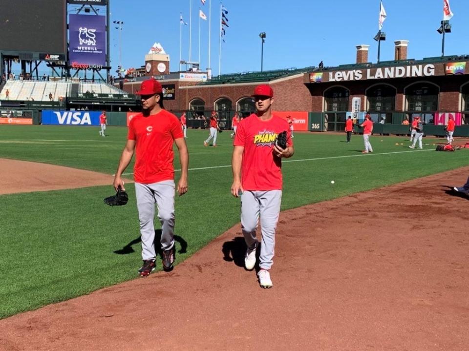 Cincinnati Reds pitchers Luis Castillo and Tyler Mahle, right, walk toward the dugout after playing catch prior to Friday's game against the San Francisco Giants.