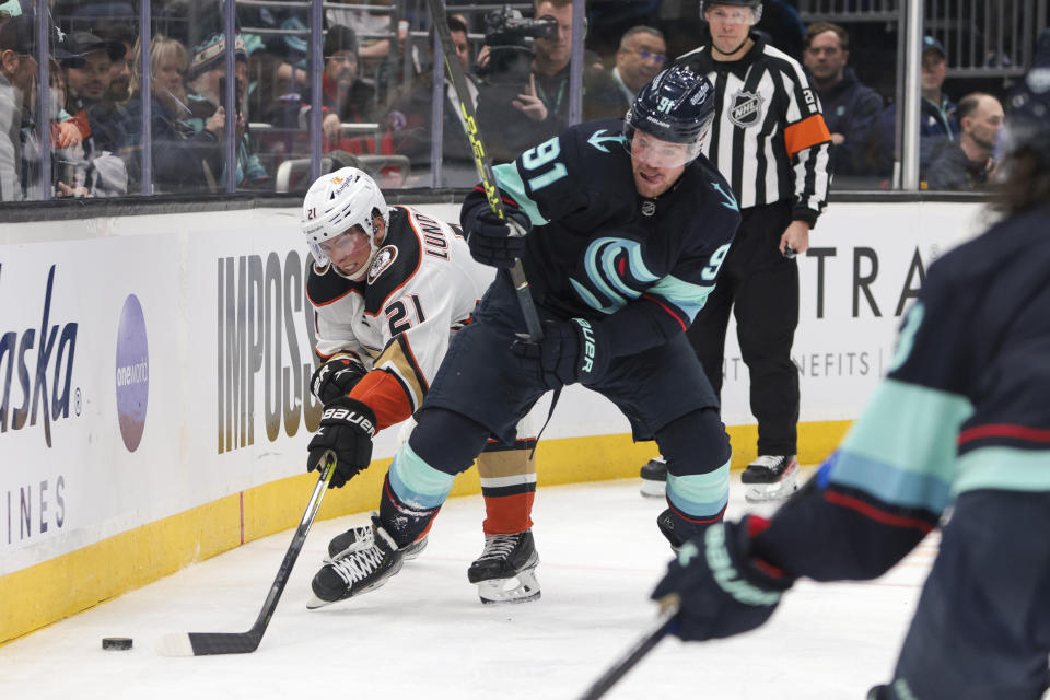 Anaheim Ducks center Isac Lundestrom, left, and Seattle Kraken right wing Daniel Sprong compete for the puck behind the Anaheim goal during the third period of an NHL hockey game Tuesday, March 7, 2023, in Seattle. The Kraken won 5-2. (AP Photo/Jason Redmond)