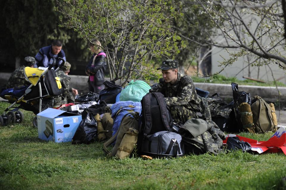 A Ukrainian serviceman sits with his packed things before leaving the Belbek airbase near Sevastopol, Friday, March 28, 2014. Ukraine started withdrawing its troops and weapons from Crimea, now controlled by Russia. Russia's president says Ukraine could regain some arms and equipment of military units in Crimea that did not switch their loyalty to Russia. (AP Photo/Andrew Lubimov)