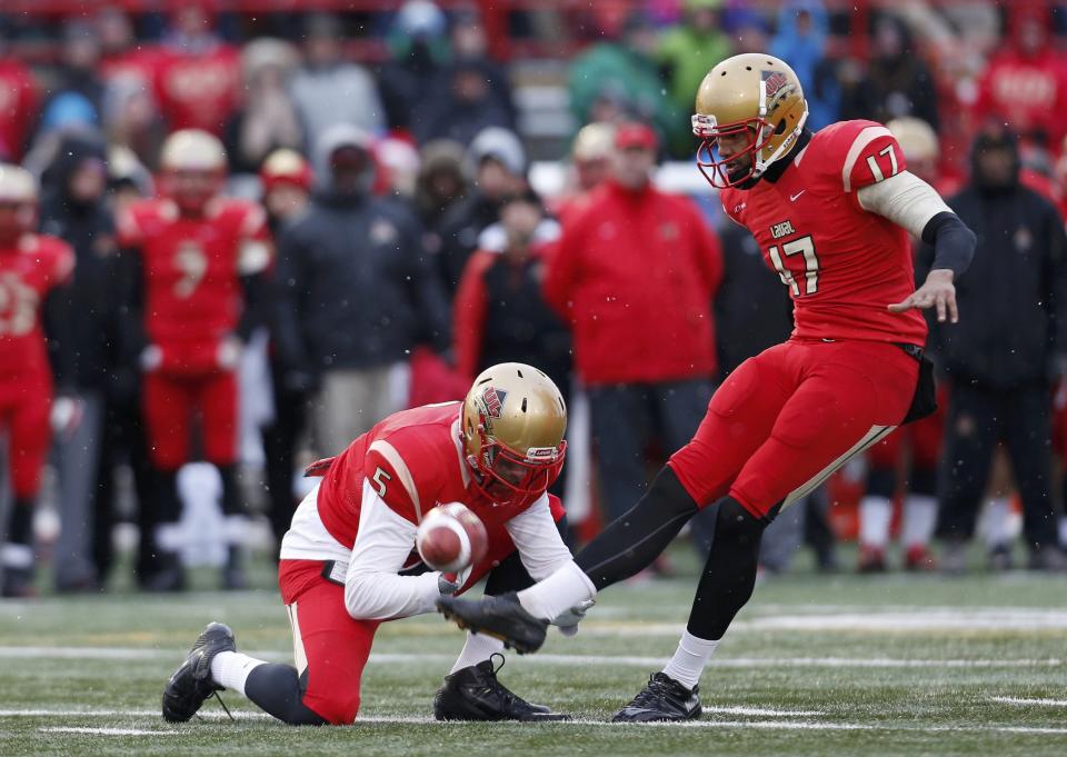 Laval Rouge et Or kicker Boris Bede (R) kicks a field goal with holder Tristan Grenon against the Calgary Dinos during the second half of the Vanier Cup University Championship football game in Quebec City, Quebec, November 23, 2013. REUTERS/Mathieu Belanger (CANADA - Tags: SPORT FOOTBALL)