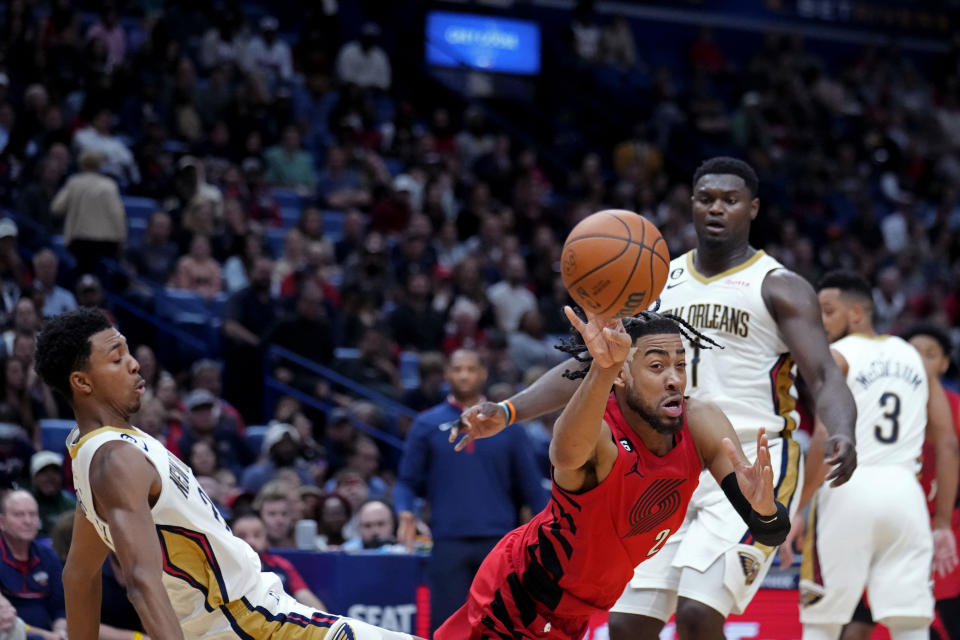 Portland Trail Blazers forward Trendon Watford (2) passes between New Orleans Pelicans guard Trey Murphy III, left, and forward Zion Williamson (1) in the second half of an NBA basketball game in New Orleans, Thursday, Nov. 10, 2022. The Trail Blazers won 106-95. (AP Photo/Gerald Herbert)