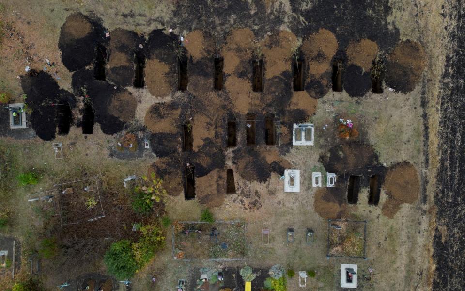 An aerial picture shows freshly dug graves at the cemetery in the village of Hroza, near Kharkiv
