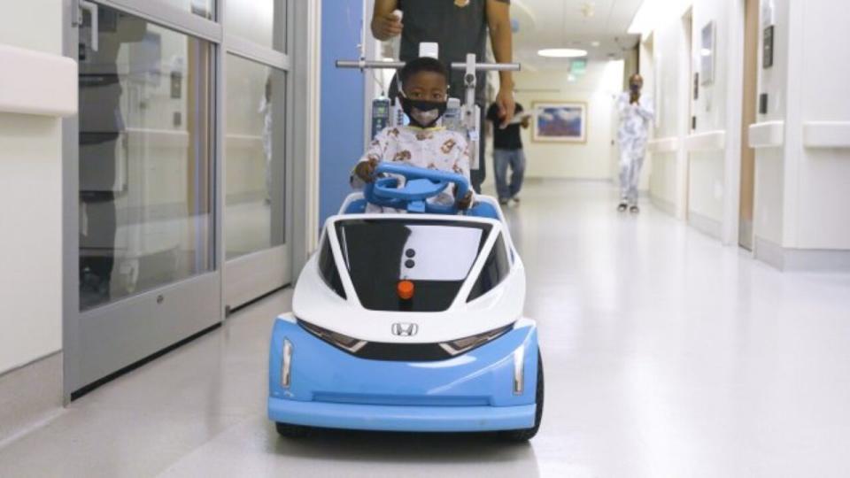 Child patient at Children's Health of Orange County drives the miniature Honda Shogo EV around the hospital.