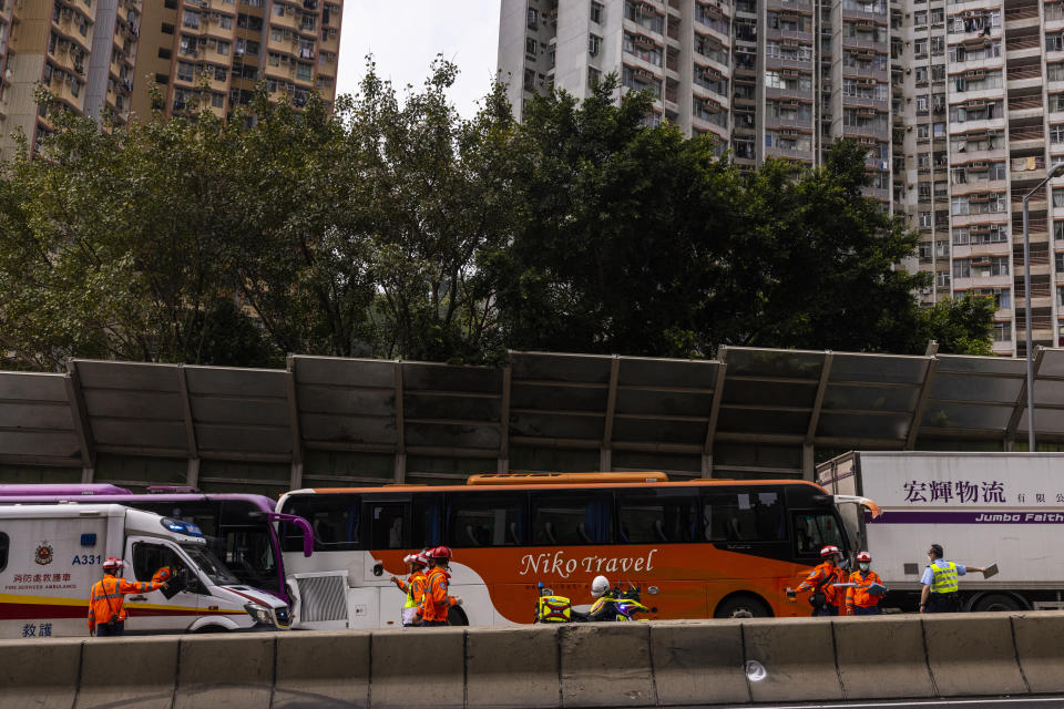 Police inspect after an accident on a highway in Hong Kong, Friday, March 24, 2023. Four passenger buses and a truck collided near a Hong Kong road tunnel Friday, injuring dozens of people. (AP Photo/Louise Delmotte)