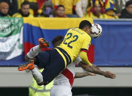 Colombia's Jeison Murillo heads the ball while jumping over Peru's Paolo Guerrero during their first round Copa America 2015 soccer match at Estadio Municipal Bicentenario German Becker in Temuco, Chile, June 21, 2015. REUTERS/Carlos Garcia Rawlins