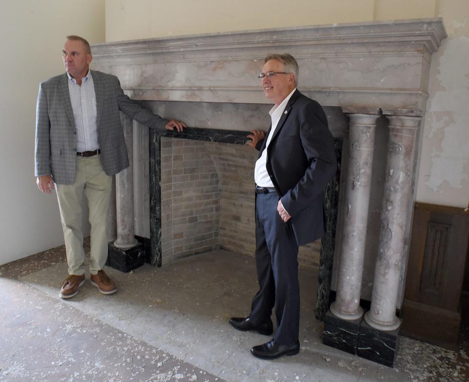 Developer Keith Masserant (left) stands near the Academy's original marble fireplace with Monroe Mayor Robert Clark.