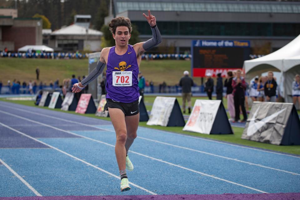 Marshfield’s Alexander Garcia-Silver smiles as he sprints down the final stretch to win the 4A Boys 5,000 meters at the OSAA State Cross Country Championships Saturday Nov. 5, 2022, at Lane Community College in Eugene. The title was his second consecutive state meet win.