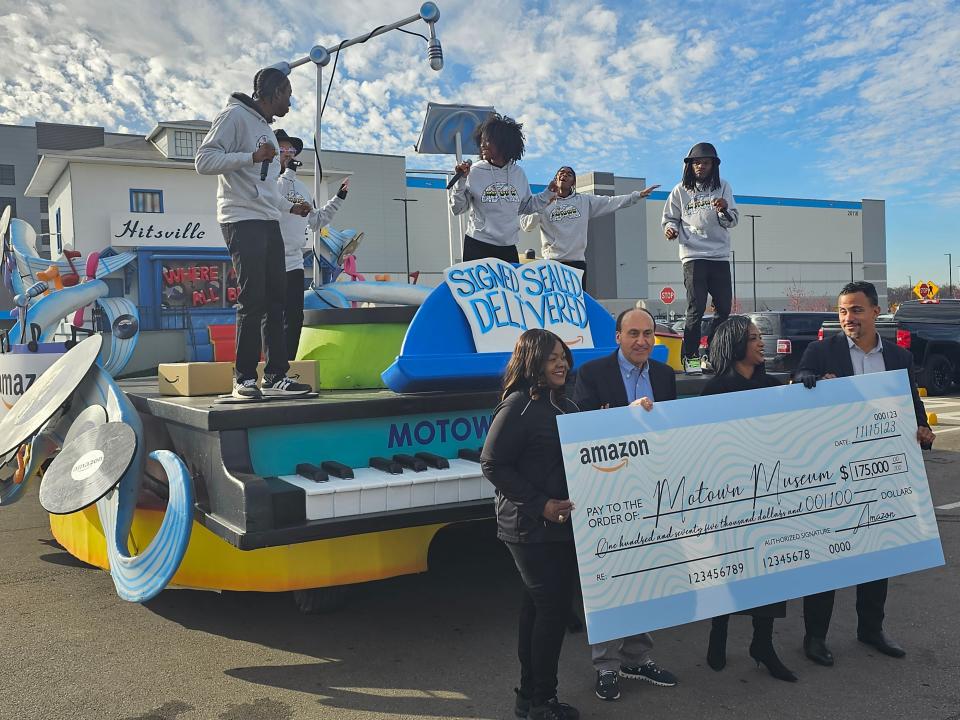 Front, from left: Donetta Houser-Sly of Amazon, Tony Michaels of the Parade Company, Robin Terry of the Motown Museum and Ian Conyers of Amazon pose in front of the Motown Museum float at the Amazon Detroit Fulfillment Center on Nov. 15, 2023.