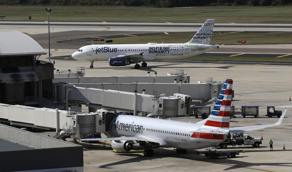 FILE - A JetBlue Airbus A320 taxis to a gate after landing, Oct. 26, 2016, as an American Airlines jet is seen parked at its gate at Tampa International Airport in Tampa, Fla. JetBlue on Wednesday, July 5, 2023, said it won't appeal a judge's ruling against its partnership with American Airlines, effectively dropping the deal in an effort to salvage its purchase of Spirit Airlines. (AP Photo/Chris O'Meara, File)