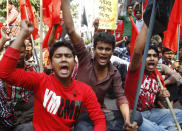 Bangladeshi garment workers shout slogans as they participate in a protest to mourn the death of the victims of a fire in a garment factory in Dhaka, Bangladesh, Friday, Nov. 30, 2012. Hundreds of garment workers protested Friday outside the Bangladeshi factory where 112 people were killed by the fire, demanding compensation for their lost salaries. The placard behind reads: "Stop looting from the garment sector." (AP Photo/Pavel Rahman)