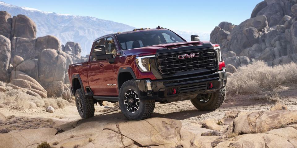 2024 gmc sierra 2500hd at4x in volcanic red tintcoat tackling rocky off road conditions