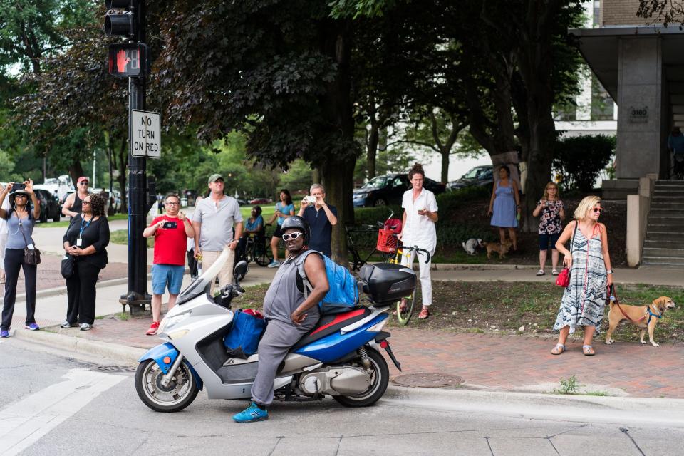 People along Belmont Avenue watch as a protest against gun violence passes by in Chicago on August 2, 2018.