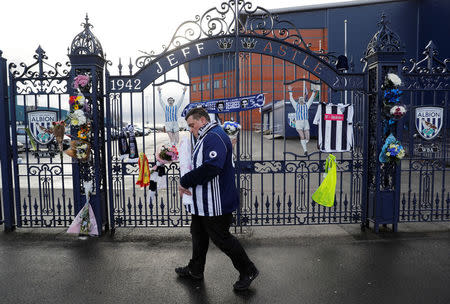 A fan walks away after leaving a tribute to Cyrille Regis at the Jeff Castle gates of West Bromwich Albion football club's The Hawthorns stadium in West Bromwich, Britain January 15, 2018. REUTERS/Darren Staples