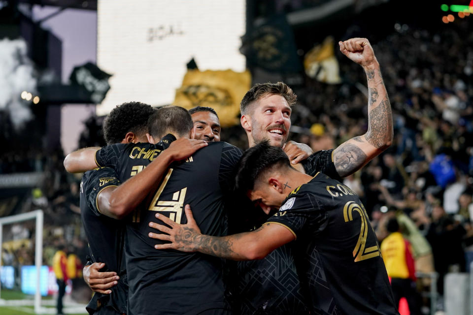 Los Angeles FC midfielder Ryan Hollingshead, top right, is surrounded by teammates after his goal against the Vancouver Whitecaps during the second half of an MLS playoff soccer match Saturday, Oct. 28, 2023, in Los Angeles. (AP Photo/Ryan Sun)