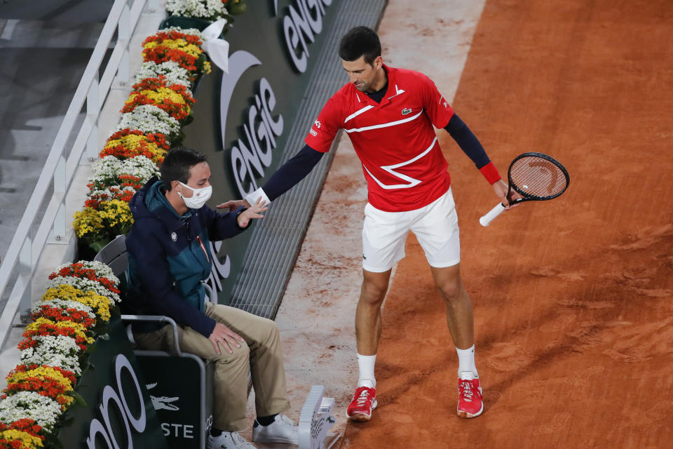 Serbia's Novak Djokovic checks on a linesman after a ball spun off his racket in the fourth round match of the French Open tennis tournament against Russia's Karen Khachanov at the Roland Garros stadium in Paris, France, Monday, Oct. 5, 2020. (AP Photo/Christophe Ena)
