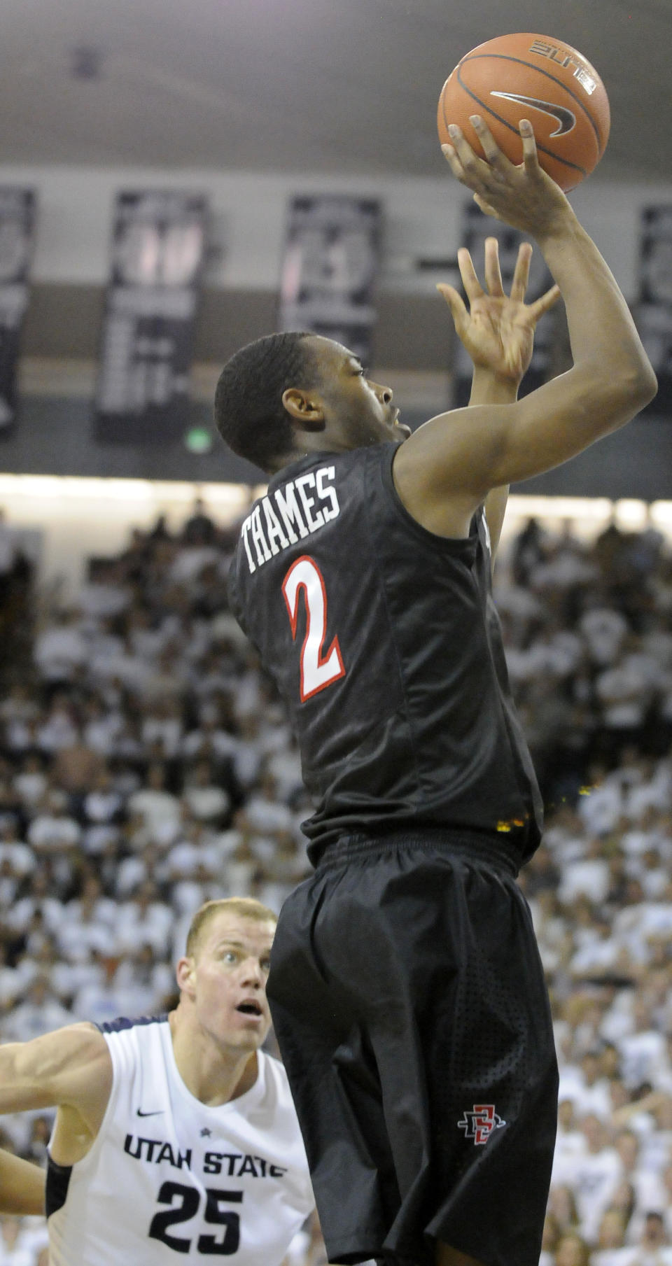 San Diego State guard Xavier Thames (2) takes a shot as Utah State center Jordan Stone (25) defends in the first half of an NCAA college basketball game Saturday, Jan. 25, 2014, in Logan, Utah. (AP Photo/Eli Lucero)