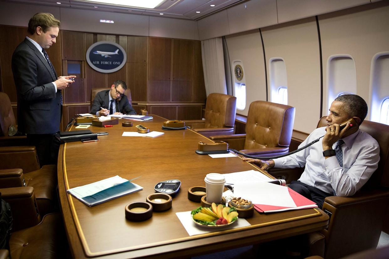 Barack Obama speaks on the phone in a conference room on Air Force One.