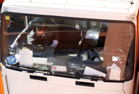 An investigator is seen inside a gas cylinder delivery truck with bullet holes in its windscreen after police fired shots to stop the driver, whom they say had stolen the truck and was driving against traffic, in Barcelona, Spain, February 21, 2017. REUTERS/Albert Gea