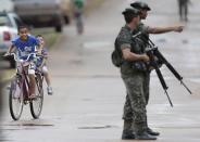 Brazilian Army soldiers patrol a street as part of the operation named "Agata" in the town of Oiapoque, on the border with French Guiana, May 15, 2014. Operation Agata is a Brazilian armed forces operation in coordination with other federal agencies to combat cross-border crimes such as drug trafficking, smuggling of arms and goods, environmental crimes, illegal immigration, and illegal mining. Picture taken May 15, 2014. REUTERS/Ueslei Marcelino (BRAZIL - Tags: POLITICS MILITARY)