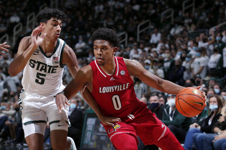 Louisville's Noah Locke, right, drives against Michigan State's Max Christie during the first half of an NCAA college basketball game Wednesday, Dec. 1, 2021, in East Lansing, Mich. (AP Photo/Al Goldis)
