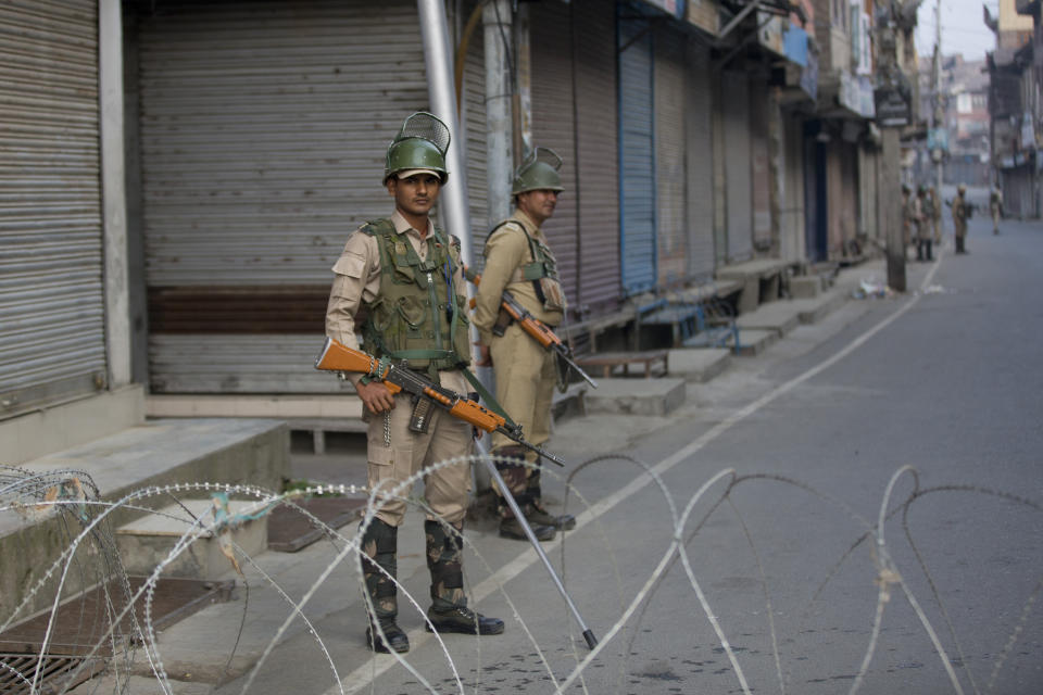 Indian paramilitary soldiers stands guard near a barbed wire barricade during restrictions in Srinagar Indian controlled Kashmir, Friday, Sept. 27, 2019. Residents in Indian-controlled Kashmir waited anxiously as Indian and Pakistani leaders were scheduled to speak at the U.N. General Assembly later Friday. (AP Photo/ Dar Yasin)