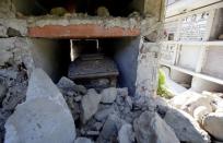 A coffin covered by debris is seen in a cemetery following an earthquake at Sant' Angelo near Amatrice, central Italy, August 26, 2016. REUTERS/Max Rossi