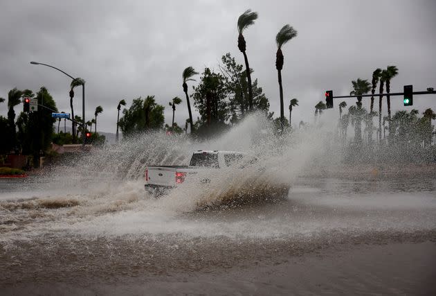 A vehicle drives through a flooded street in Cathedral City, California.