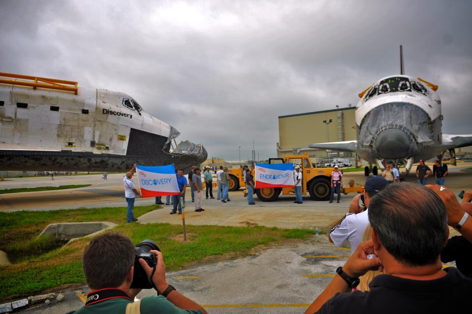 Space Shuttle Endeavour (R), leaving the Orbiter Processing Facility on its way to the Vehicle Assembly Building (VAB), passes Space Shuttle Discovery at Kennedy Space Center August 11, 2011 in Cape Canaveral, Florida. Space Shuttles Endeavour and Discovery switched buildings as they are being decommissioned with the end of the Shuttle program. (Photo by Roberto Gonzalez/Getty Images)