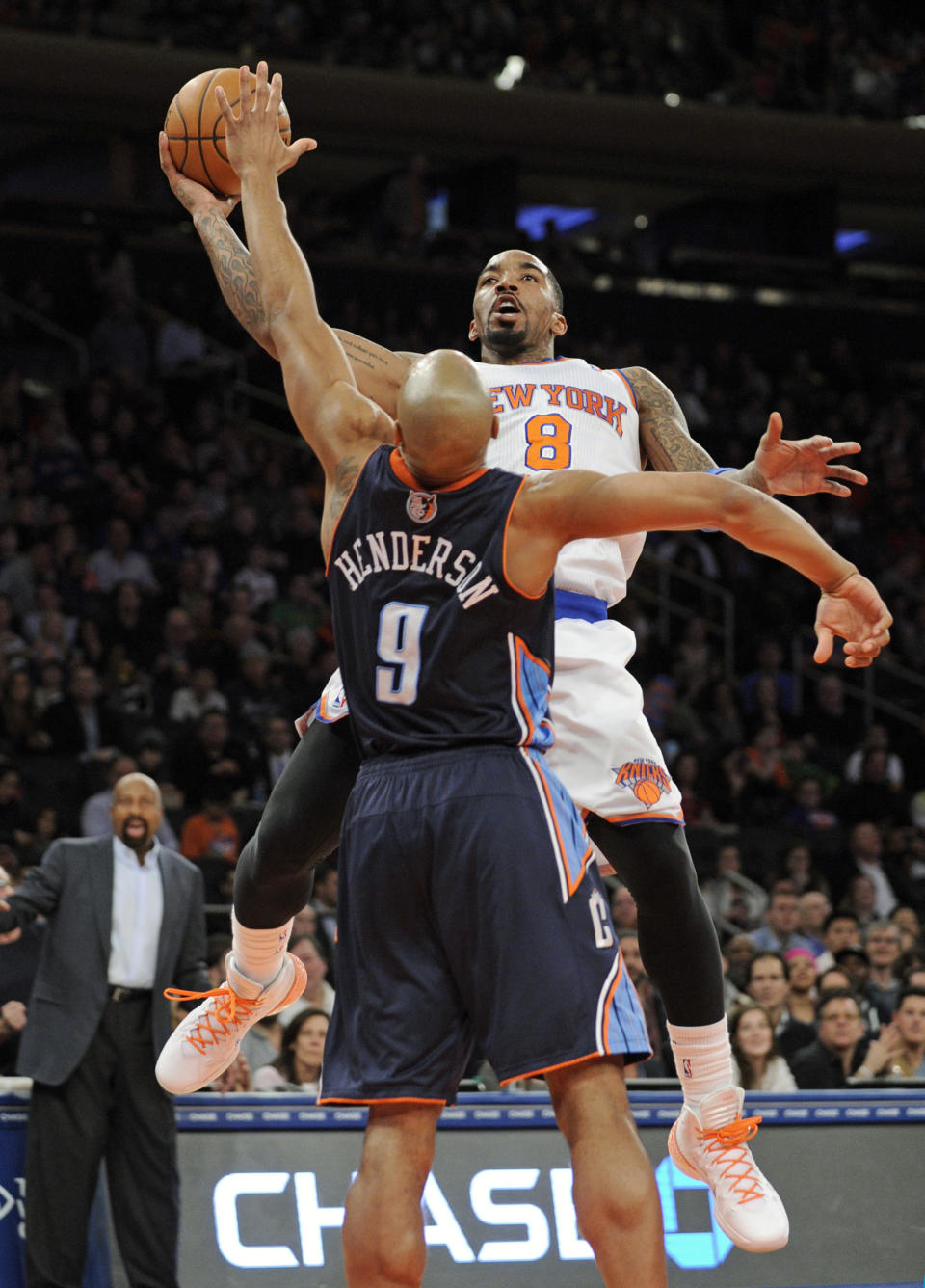 New York Knicks' J.R. Smith, right, puts up a shot over Charlotte Bobcats' Gerald Henderson during the second quarter of an NBA basketball game, Friday, Jan. 24, 2014, at Madison Square Garden in New York. The Knicks won 125-96. (AP Photo/Bill Kostroun)