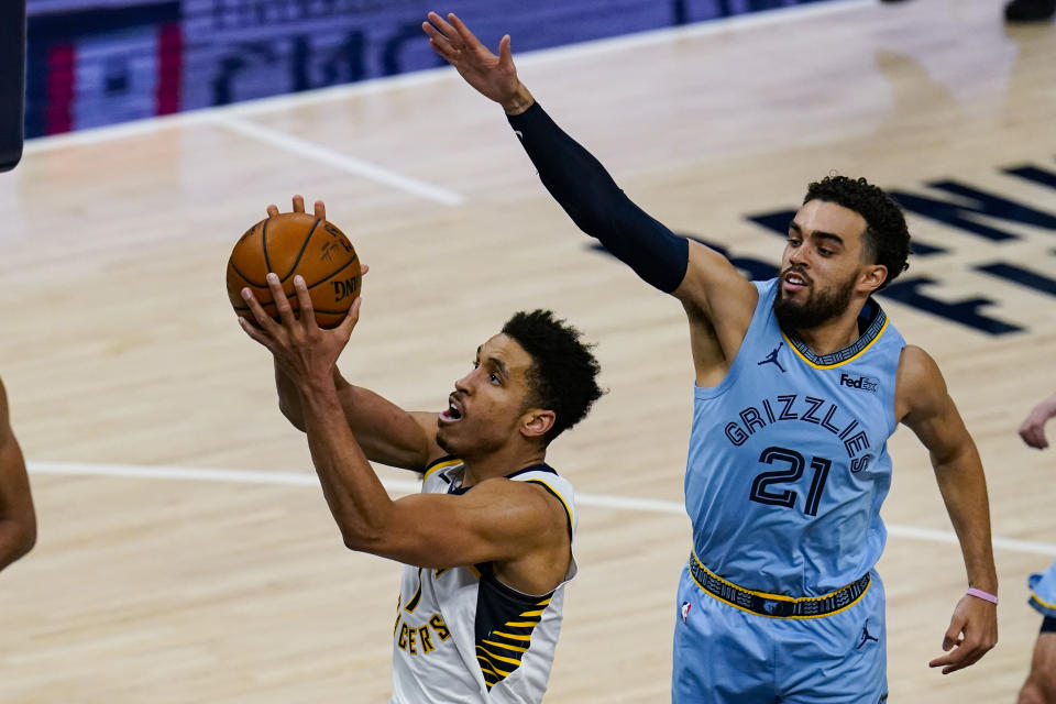 Indiana Pacers guard Malcolm Brogdon (7) shoots in front of Memphis Grizzlies guard Tyus Jones (21) during the second half of an NBA basketball game in Indianapolis, Tuesday, Feb. 2, 2021. (AP Photo/Michael Conroy)