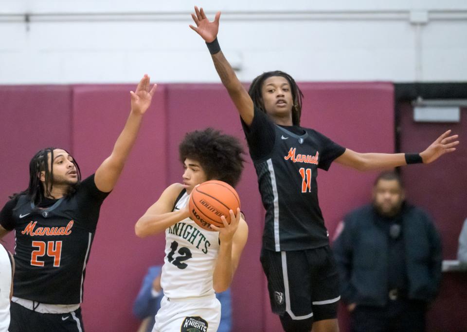 Manual's Marquis Woodson (24) and Dietrich Richardson (11) defend against Richwoods' Greg Burnside in the second half of the Class 3A Boys Basketball Peoria Regional title game Friday, Feb. 24, 2023 at Peoria High School. The Knights defeated the Rams 64-56.