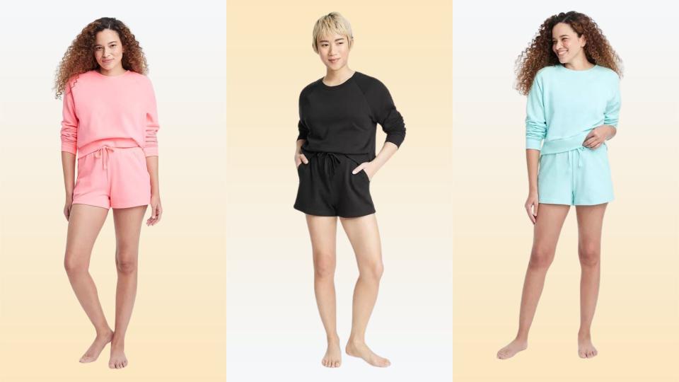 Three models wearing the shorts in pink, black and blue on a yellow background. 