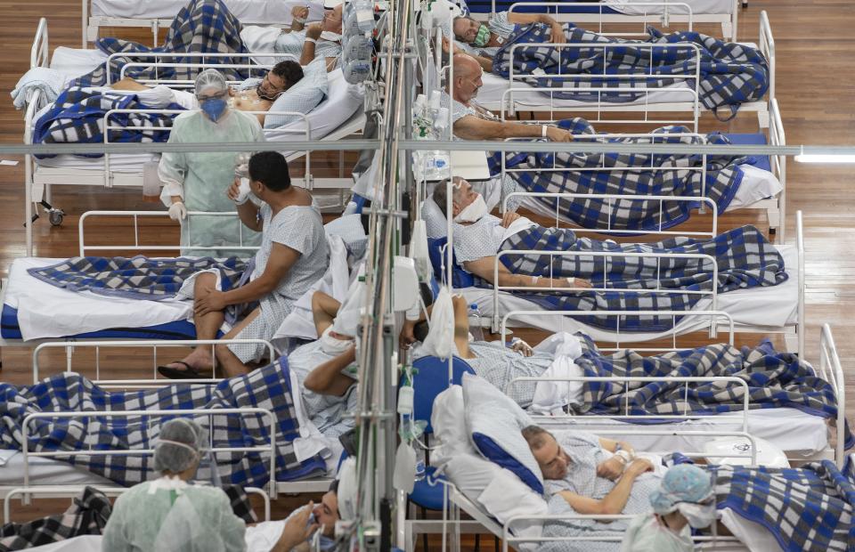 FILE - In this Tuesday, June 9, 2020 file photo COVID-19 patients lie on beds in a field hospital built inside a gym in Santo Andre, on the outskirts of Sao Paulo, Brazil. For months, experts have warned of a potential nightmare scenario: After overwhelming health systems in some of the world's wealthiest regions, the coronavirus gains a foothold in poor or war-torn countries ill-equipped to contain it and sweeps through the population. (AP Photo/Andre Penner, File)