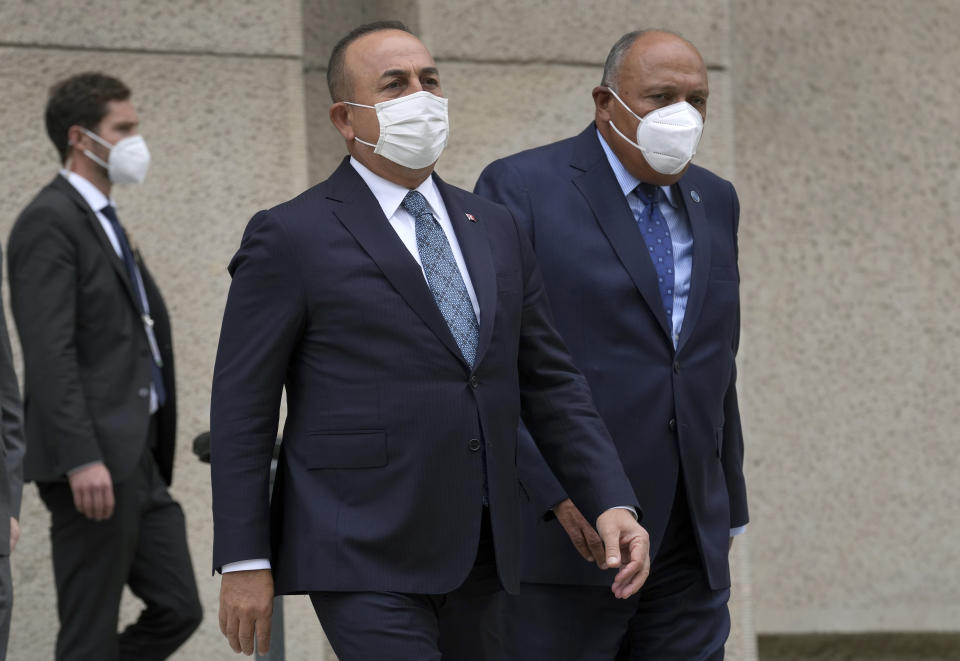 Turkey's Foreign Minister Mevlut Cavusoglu, left, and his counterpart from Egypt, Sameh Shoukry, right, arrive for a group photo during the 'Second Berlin Conference on Libya' at the foreign office in Berlin, Germany, Wednesday, June 23, 2021. (AP Photo/Michael Sohn, pool)