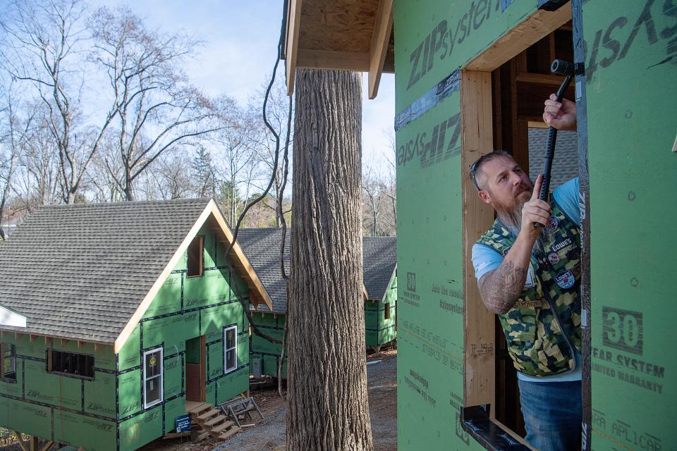 Joe Strong, a store manager at Lowe’s, weatherizes a window frame at the BeLoved Village, November 14, 2023, in Asheville.