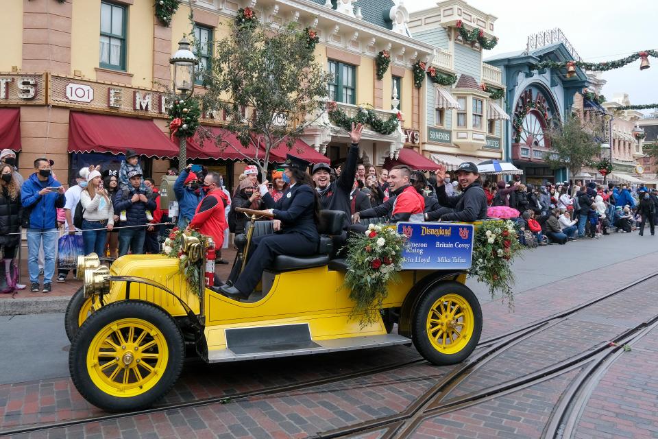 Ventura's Cameron Rising (right) rides on a vehicle with Utah teammates Britain Covey, Devin Lloyd and Mika Tafua in a parade for the Rose Bowl Team Visit at the Disneyland Resort in Anaheim on Monday.
