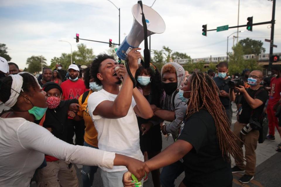 Demonstrators protest outside a police station on 11 August in Chicago in response to a shooting of a 20-year-old man who allegedly fired at officers in the Englewood neighborhood.