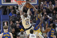 Golden State Warriors forward Draymond Green, top right, blocks a shot by Dallas Mavericks center Daniel Gafford (21) during the second half of an NBA basketball game in San Francisco, Tuesday, April 2, 2024. (AP Photo/Jeff Chiu)