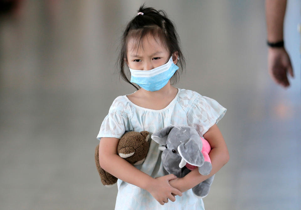 A girl wears a mask as she walks past a scanning machine monitoring people's temperature following the new coronavirus outbreak from China, at Bandaranaike international airport in Katunayake, Sri Lanka January 24, 2020. REUTERS/Dinuka Liyanawatte