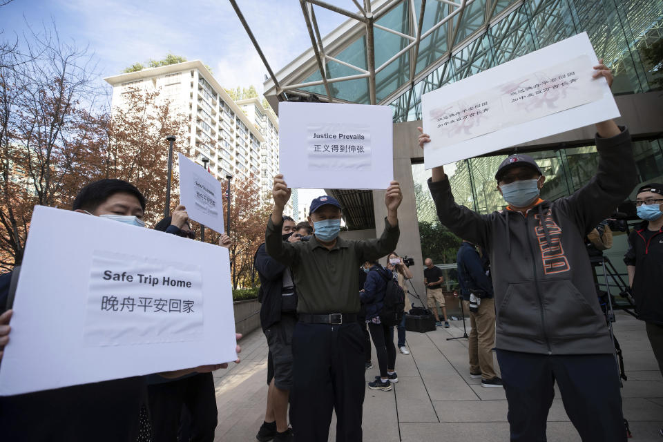 Supporters of Meng Wanzhou, chief financial officer of Huawei, hold signs outside B.C. Supreme Court in Vancouver, British Columbia, Friday, Sept. 24, 2021. (Darryl Dyck/The Canadian Press via AP)