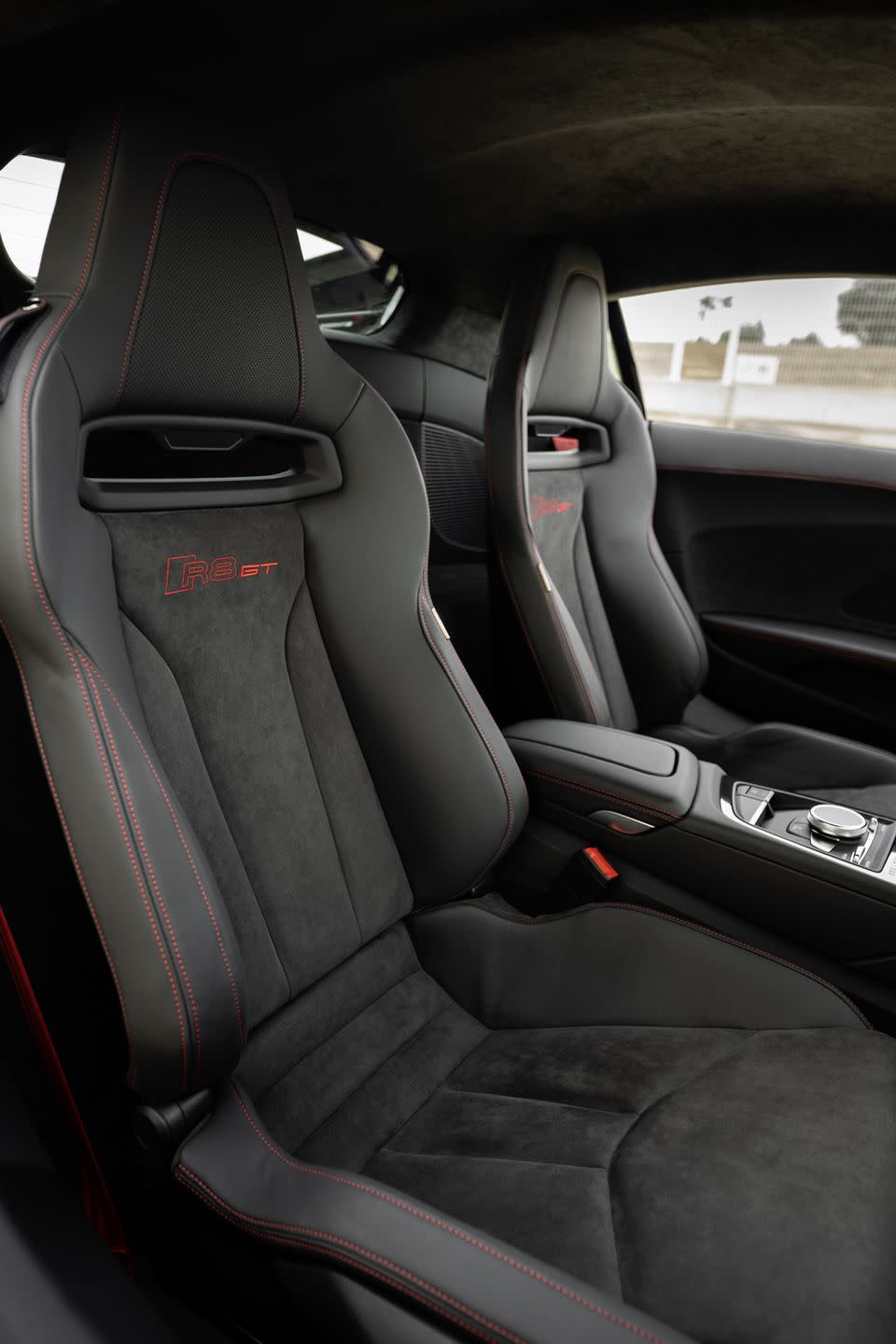 <p>The GT's fixed-back bucket seats are more relaxed fit than many others, neither too narrow nor with steep bolstering at their periphery. It kind of fits with the R8's more daily-driver vibe, which includes a very useful parcel shelf behind the seats.</p>
