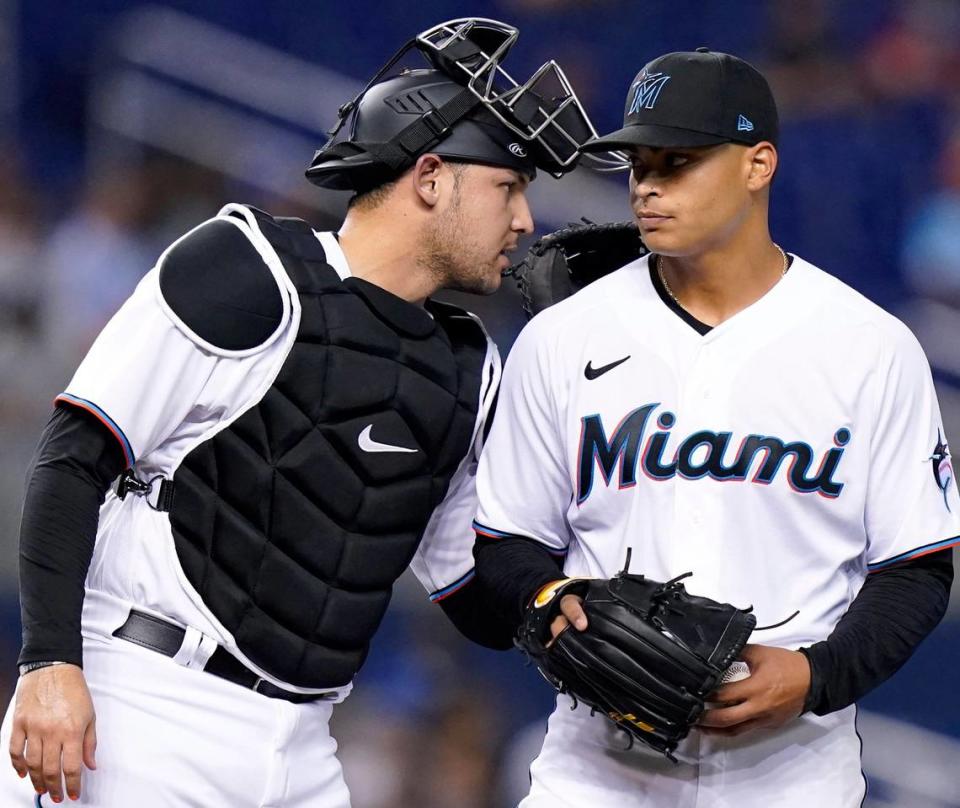 Miami Marlins catcher Alex Jackson, left, talks with Miami Marlins starting pitcher Jesus Luzardo, right, during the second inning of a baseball game against the New York Mets, Monday, Aug. 2, 2021, in Miami.