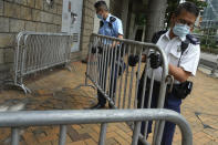 Police officers set up barriers as they wait for Tong Ying-kit's arrival at the Hong Kong High Court in Hong Kong Friday, July 30, 2021. Tong Ying-kit was convicted Tuesday of inciting secession and terrorism for driving his motorcycle into a group of police officers during a July 1, 2020, pro-democracy rally while carrying a flag bearing the banned slogan, "Liberate Hong Kong, revolution of our times." Tong, 24, will be sentenced Friday, the court announced. (AP Photo/Vincent Yu)