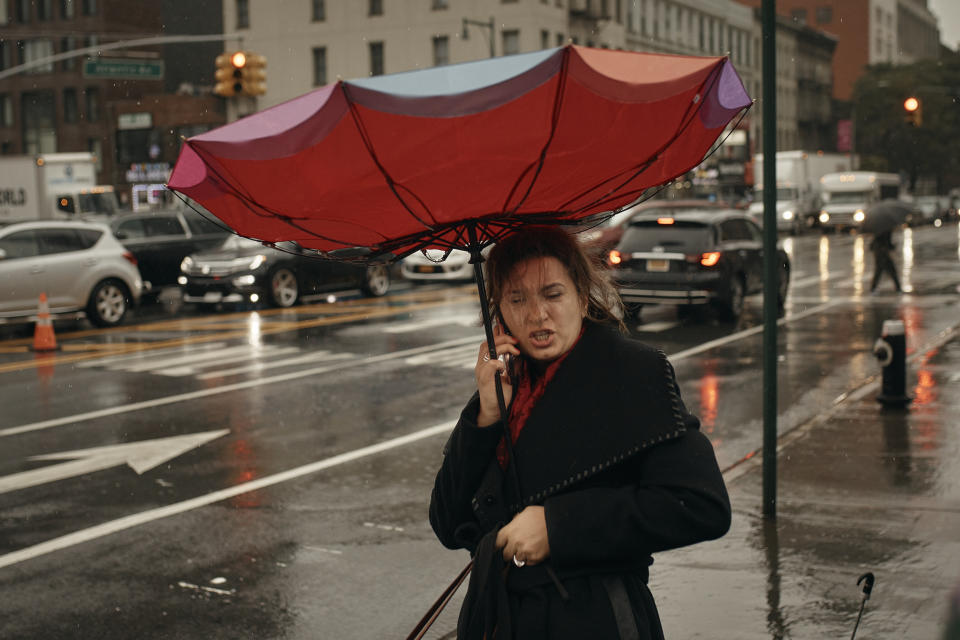 A woman holds her umbrella as she speaks on the phone on Friday, Sept. 29, 2023 in Brooklyn borough of New York. A potent rush-hour rainstorm swamped the New York metropolitan area on Friday, shutting down some subways and commuter railroads, flooding streets and highways, and delaying flights into LaGuardia Airport. (AP Photo/Andres Kudacki)