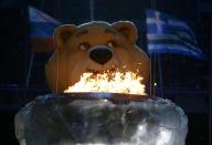 An Olympic Games mascot pauses before extinguishing the Olympic flame in a small cauldron in the stadium during the closing ceremony for the Sochi 2014 Winter Olympics, February 23, 2014. REUTERS/Marko Djurica (RUSSIA - Tags: SPORT OLYMPICS)