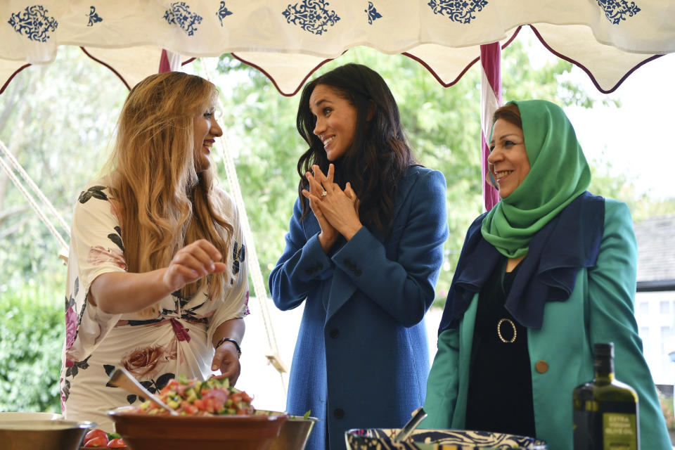 Meghan, the Duchess of Sussex, centre reacts with unidentified women involved with the cookbook "Together" during a reception at Kensington Palace, in London, Thursday Sept. 20, 2018. The Duchess was joined by her mother Doria Ragland and husband Prince Harry for the launch of a cookbook aimed at raising money for victims of the Grenfell fire. (Ben Stansall/Pool Photo via AP)